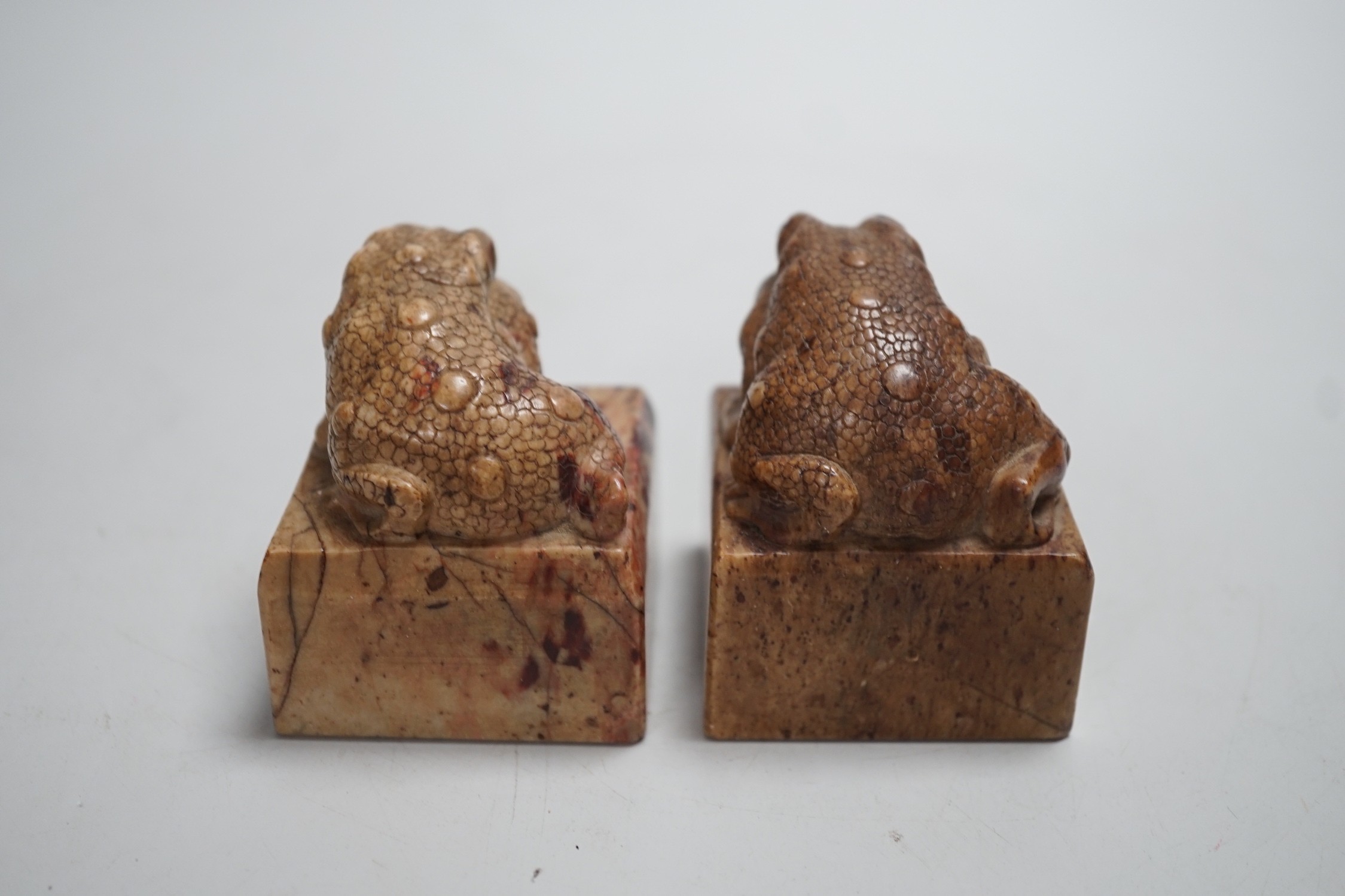 A pair of Chinese carved soapstone chop seals decorated as seated toads, 6cm